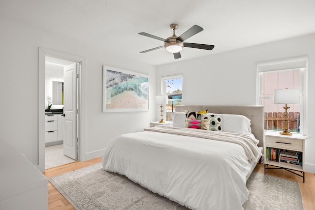 bedroom featuring light hardwood / wood-style flooring, connected bathroom, and ceiling fan