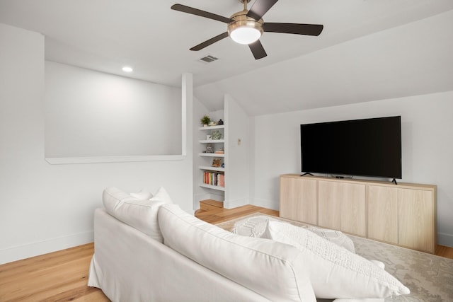 living room featuring ceiling fan, built in features, light hardwood / wood-style floors, and lofted ceiling