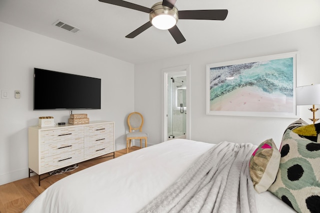 bedroom featuring ceiling fan, ensuite bathroom, and dark hardwood / wood-style flooring