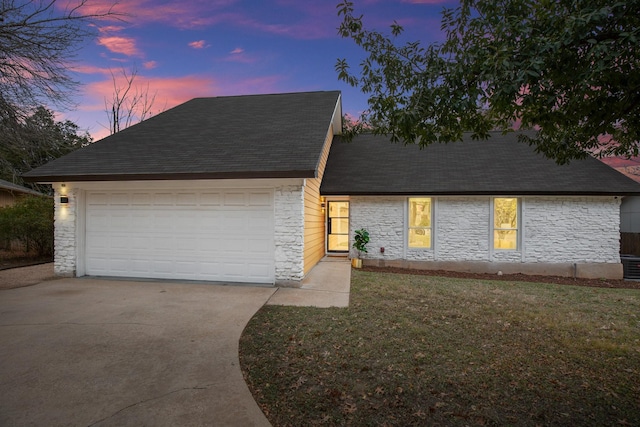 view of front of home with a garage and a lawn