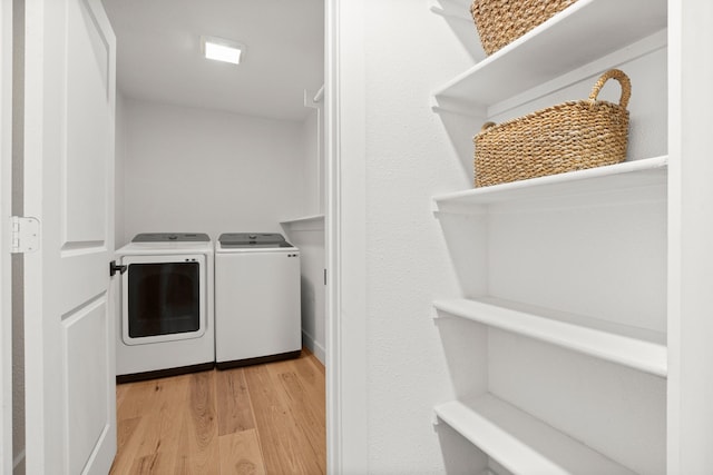 laundry area with washer and dryer and light hardwood / wood-style floors