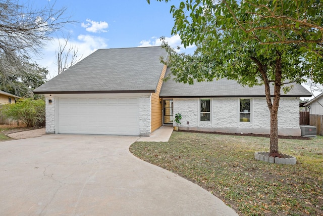 view of front of home featuring a garage, a front lawn, and central AC