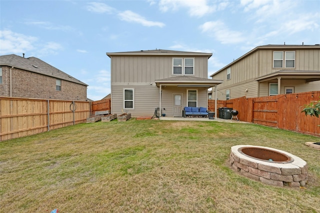 rear view of property with a patio area, a lawn, and an outdoor living space with a fire pit