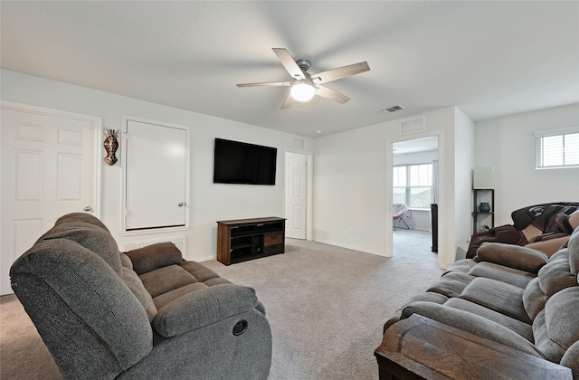 carpeted living room with ceiling fan