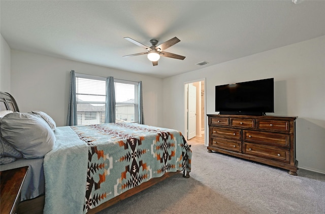 carpeted bedroom with ceiling fan and connected bathroom