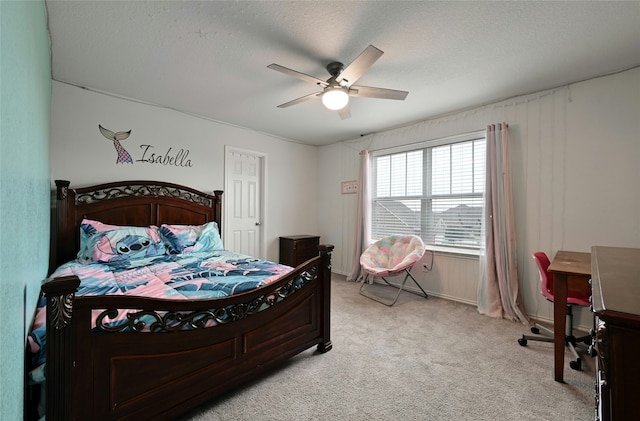 carpeted bedroom featuring ceiling fan and a textured ceiling