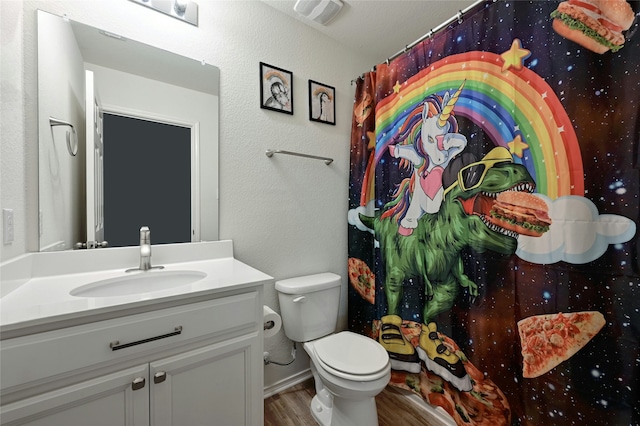 bathroom featuring wood-type flooring, toilet, and vanity