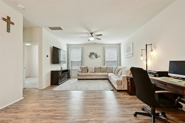 home office featuring light wood-type flooring and ceiling fan