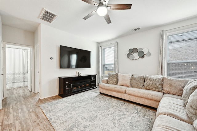 living room featuring ceiling fan and light hardwood / wood-style floors