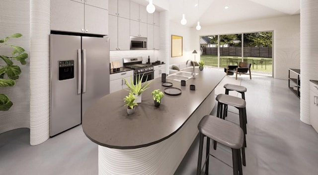 kitchen featuring white cabinets, a breakfast bar area, hanging light fixtures, and stainless steel appliances