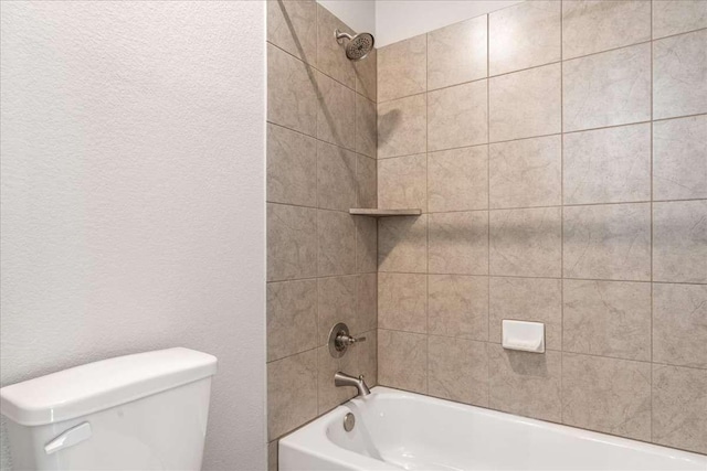 bathroom featuring toilet and tiled shower / bath combo