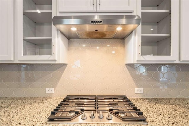 kitchen featuring white cabinets, exhaust hood, and tasteful backsplash