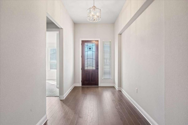 foyer featuring an inviting chandelier and dark hardwood / wood-style floors