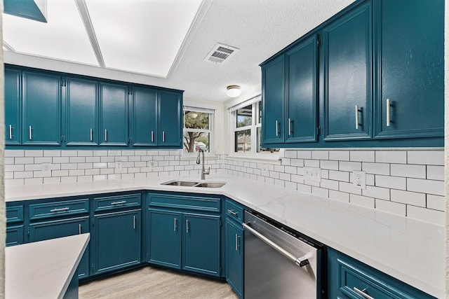 kitchen featuring light hardwood / wood-style floors, sink, dishwasher, and blue cabinets