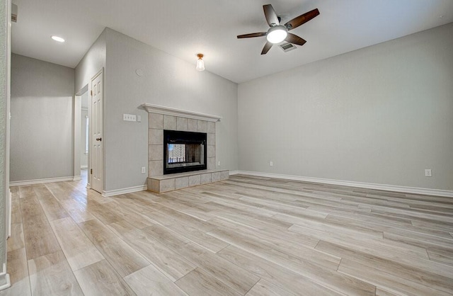 unfurnished living room with a tile fireplace, light hardwood / wood-style floors, and ceiling fan