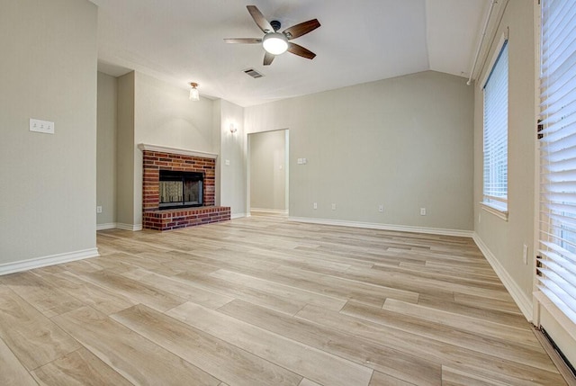 unfurnished living room with ceiling fan, vaulted ceiling, light hardwood / wood-style flooring, and a fireplace