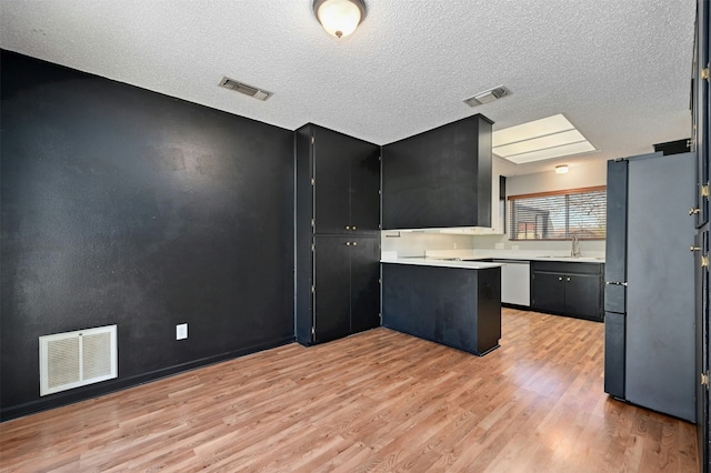 kitchen featuring light hardwood / wood-style floors, sink, a textured ceiling, and stainless steel appliances