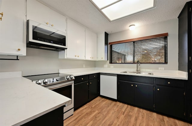 kitchen featuring dishwashing machine, white cabinets, a textured ceiling, sink, and stainless steel electric range oven