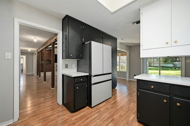 kitchen with a textured ceiling, white refrigerator, and light wood-type flooring