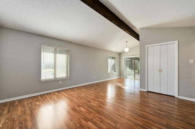 unfurnished room featuring lofted ceiling with beams, a textured ceiling, and dark hardwood / wood-style flooring