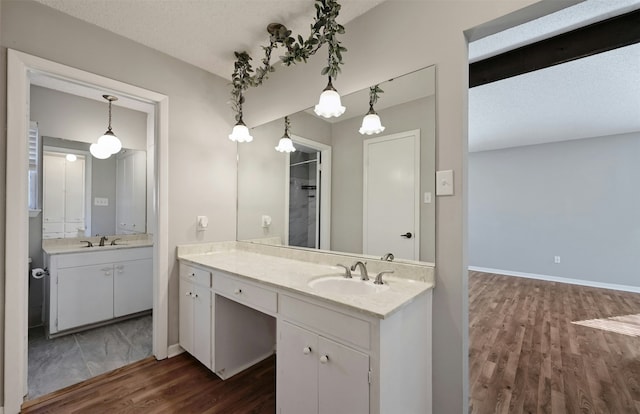 bathroom with hardwood / wood-style flooring, a textured ceiling, and vanity