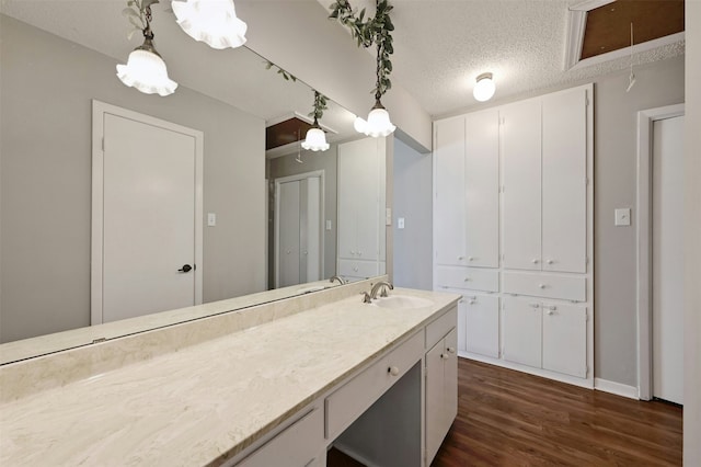 bathroom featuring vanity, hardwood / wood-style floors, and a textured ceiling