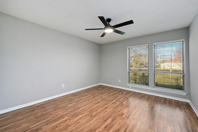 empty room with ceiling fan, hardwood / wood-style floors, and a textured ceiling