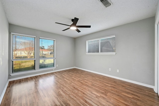 empty room with wood-type flooring, a textured ceiling, and ceiling fan