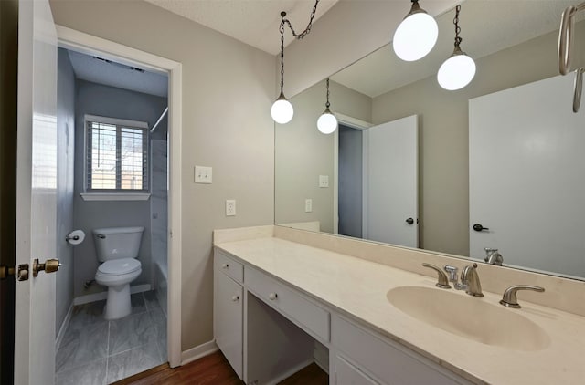 bathroom with a textured ceiling, toilet, and vanity