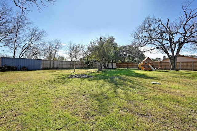 view of yard with a storage shed and a playground