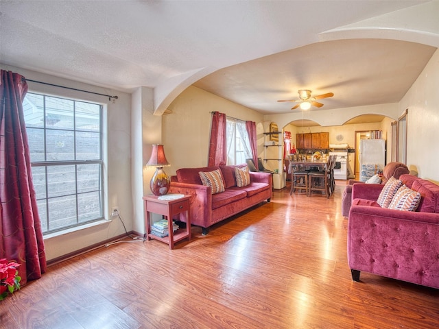 living room featuring wood-type flooring and ceiling fan