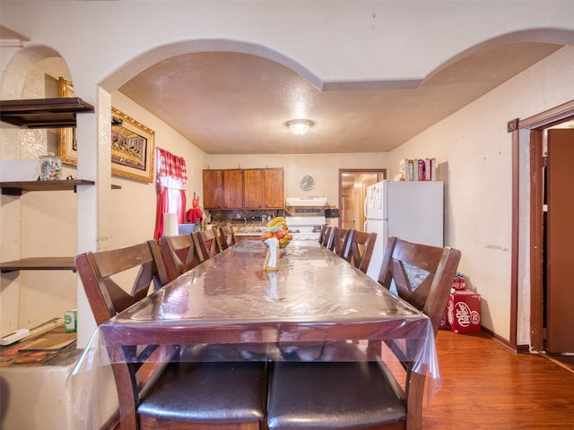 dining space with wood-type flooring