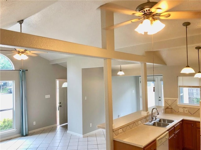 kitchen featuring pendant lighting, vaulted ceiling, white dishwasher, sink, and decorative backsplash