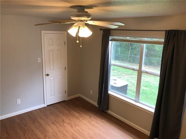 empty room with a textured ceiling, light hardwood / wood-style flooring, and ceiling fan