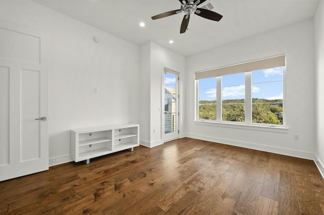 empty room with ceiling fan and dark wood-type flooring