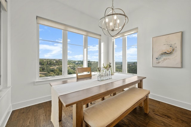 dining room with a wealth of natural light, dark hardwood / wood-style flooring, and an inviting chandelier