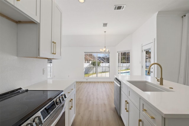 kitchen featuring light hardwood / wood-style floors, appliances with stainless steel finishes, hanging light fixtures, sink, and lofted ceiling