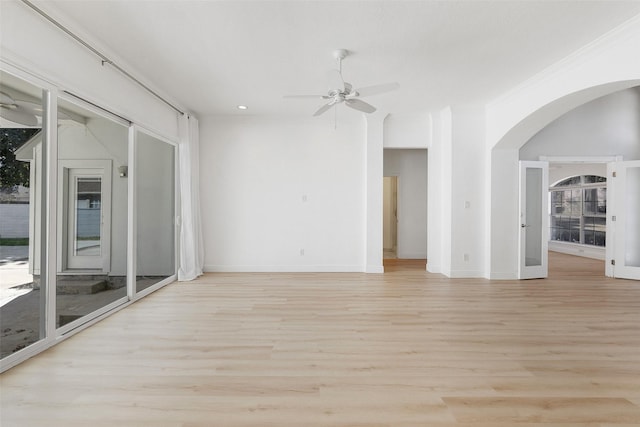 empty room with light hardwood / wood-style floors, ceiling fan, and a healthy amount of sunlight