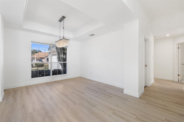 unfurnished dining area with crown molding, light hardwood / wood-style flooring, and a raised ceiling