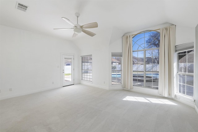 unfurnished living room featuring ceiling fan, plenty of natural light, light carpet, and vaulted ceiling