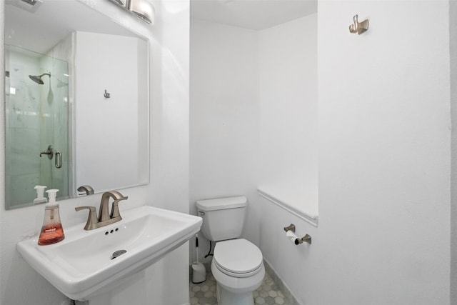 bathroom with sink, toilet, and a shower with shower door