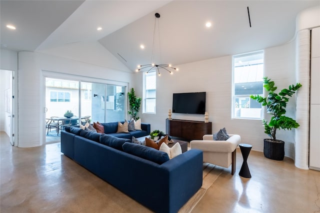 living room featuring a healthy amount of sunlight, a chandelier, and vaulted ceiling