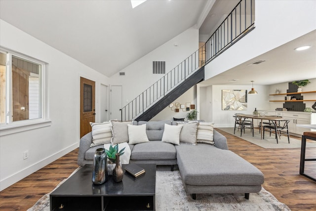 living room featuring high vaulted ceiling and dark wood-type flooring