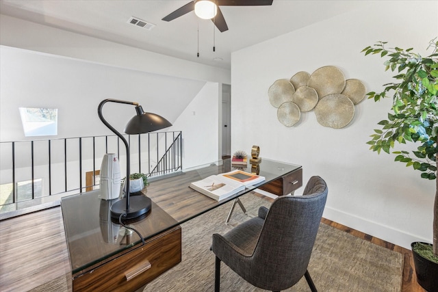 office space with a skylight, ceiling fan, and wood-type flooring