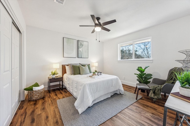 bedroom with dark wood-type flooring, a closet, and ceiling fan