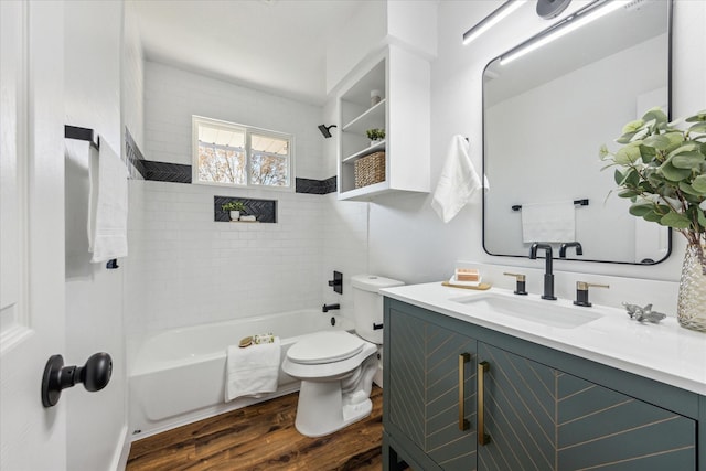 full bathroom with hardwood / wood-style flooring, toilet, tiled shower / bath, and vanity