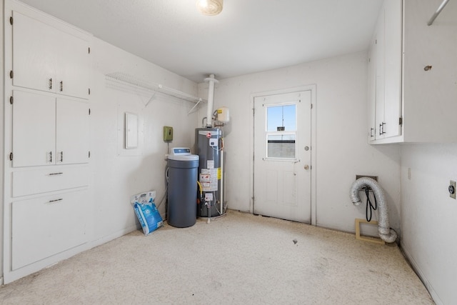 clothes washing area featuring hookup for an electric dryer, cabinets, and water heater