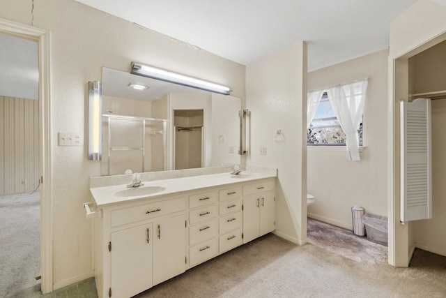 bathroom with a shower with door, toilet, and vanity