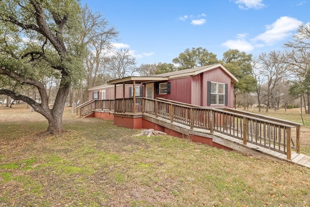 back of property with a wooden deck and a yard