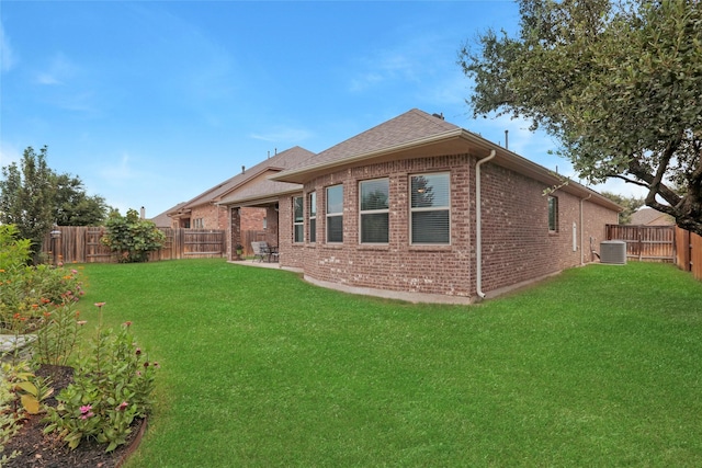 rear view of house featuring a lawn and cooling unit